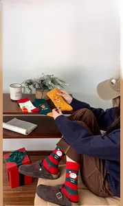 Cozy Christmas themed cotton socks featuring festive Santa and reindeer patterns in lifestyle setting