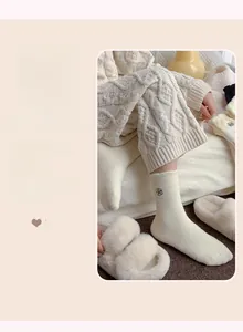 Detail of cream-colored knit socks featuring delicate black rose flower embroidery