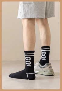 Detail of black cotton athletic socks with white GO! letter print and sport stripes