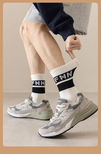 Detail of breathable white athletic mid-calf socks with black stripes and FNN lettering