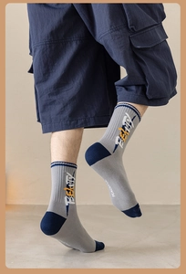 Détail de chaussettes en coton peigné avec patchwork bleu et motif lettrage jaune vif