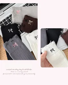 Detail of knit socks featuring embroidered bows and trendy distressed ripped cuffs