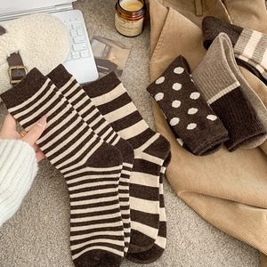 Cozy wool crew socks with brown stripes and polka dots in a warm autumn lifestyle setting