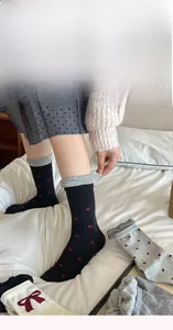 Detail view of cotton crew socks with bow and heart patterns and stylish ribbed cuffs