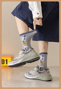 Détail de chaussettes en coton gris et bleu avec texte BEAUTY et baskets de sport rétro