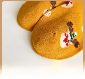 Close-up of yellow Christmas socks with reinforced toes and festive reindeer patterns
