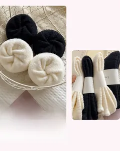 Detailed view of thick thermal socks with bow embroidery in black and off-white colors