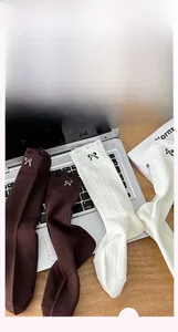 Detail of ribbed knit cotton socks featuring delicate bow embroidery and soft texture