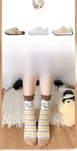Detail of cream striped socks with 3D cartoon big eyes and brown ruffle cuff design