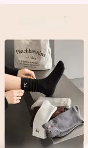 Detailed embroidery of a bow on cotton socks with elegant ruffled edges for women