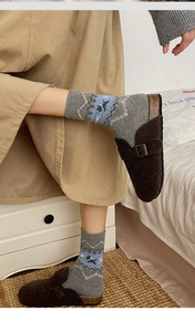 Close-up of Fair Isle wool socks with geometric patterns and brown buckle sandals