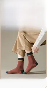 Detail der Socke im Vintage-Farblock-Design mit ziegelrotem Strick und grauen Akzenten