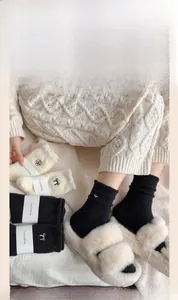 Close-up of thick winter coral fleece socks with elegant bow and camellia embroidery