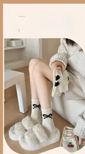 Gros plan de chaussettes en coton moucheté avec nœud noir et motifs cerises floqués