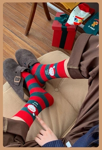 Close-up of red and green striped Christmas socks with Santa Claus motif and Lucky Day text