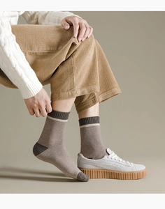 Detail einer dicken Wintersocke mit gestreiftem Rippbündchen und grauer Zehenverstärkung