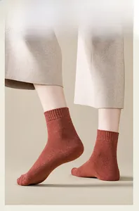 Close-up of rust red knit crew socks with elastic ribbed cuffs and soft warm texture
