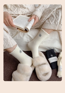 Detail of warm winter socks featuring plush texture and delicate floral embroidery