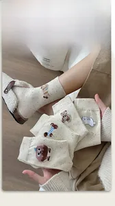 Detail of cream cable knit socks with cute 3D cartoon animal embroidery for winter
