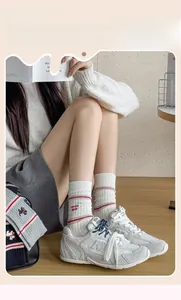 Detail of white cotton crew socks with red stripes and mucho amor embroidery