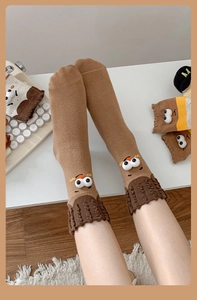 Detail of creative cartoon crew socks featuring 3D googly eyes and wavy knitted cuffs