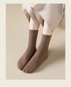 Detailed texture of thick dark brown crew socks with soft ribbed cuffs for winter