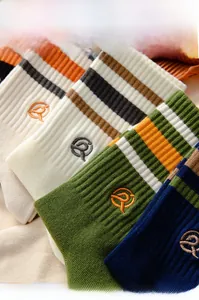 Detail of ribbed cotton socks with stripe patterns and embroidered logo in vintage style