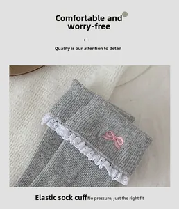 Detail of high-elastic ribbed cuff with white lace trim and pink bow embroidery