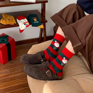 Christmas striped cotton socks with Santa Claus embroidery and festive gift box background