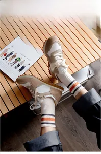 Detailed shot of retro cotton socks with orange and black stripes and vintage sneakers