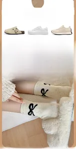 Gros plan de chaussettes beiges à motifs de nœuds noirs avec diverses chaussures élégantes