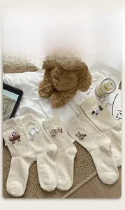 Detail of embroidered cartoon animals on cream-colored nep yarn crew socks for women