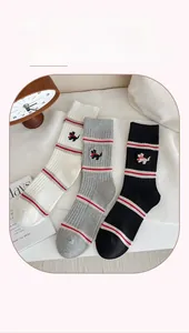 Detail showing ribbed cotton socks with puppy embroidery and stripes in white, grey, and black