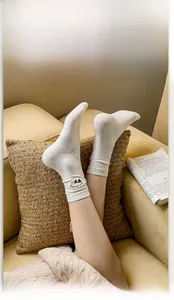 Detail of cream crew socks with bear embroidery and colorful flecks on ribbed cotton