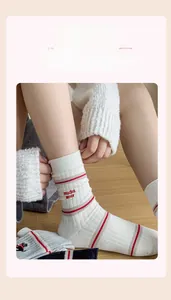 Detail of cotton socks with mucho amor embroidery and red stripes on ribbed fabric