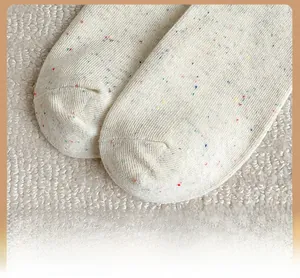 Gros plan sur la pointe renforcée de chaussettes blanc cassé avec des mouchetures colorées