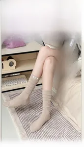 Detail of ribbed knit calf socks in beige featuring a STAYLOOSE textile label on the cuff