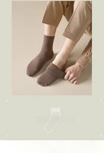 Close-up of thick brown thermal crew socks with vertical knit texture and elastic cuffs