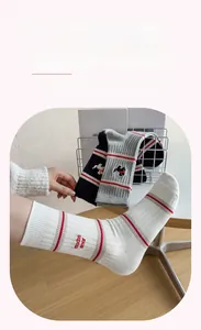 Close-up of ribbed cotton socks with much amor embroidery and sporty striped patterns