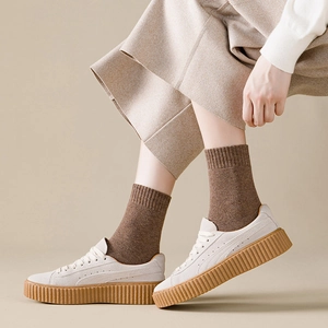Thick warm dark brown terry socks paired with cream platform sneakers for winter style