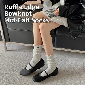 White cotton mid-tube socks with elegant ruffle edges and black embroidery bow details