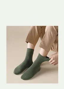 Detail of dark green knit thermal crew sock featuring ribbed cuffs and soft texture