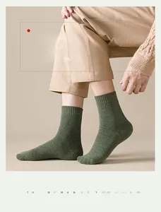 Close-up of thick ribbed cuffs on warm heather green crew socks for men in winter