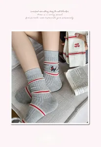 Detail of grey crew socks with cute puppy embroidery and striped rib cuffs for women