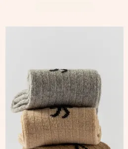 Close-up of thick ribbed wool blend socks in gray and camel tones with jacquard details