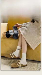 Detailed view of mid-calf cotton socks with cute bear embroidery in a cozy home setting