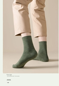 Detail of dark green ribbed crew sock with marled texture and elastic cuff