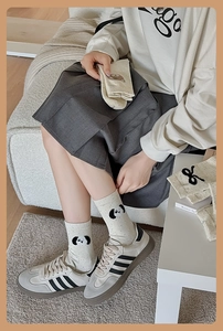 Gros plan de chaussettes beiges à pois noirs avec broderie tête de panda mignonne
