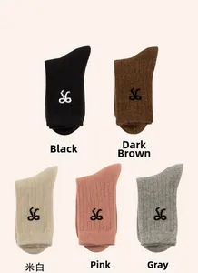 Close-up of five pairs of ribbed wool socks in black, coffee, beige, pink, and grey