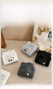 Detailed view of four pairs of ribbed cotton socks featuring cute bear and text embroidery
